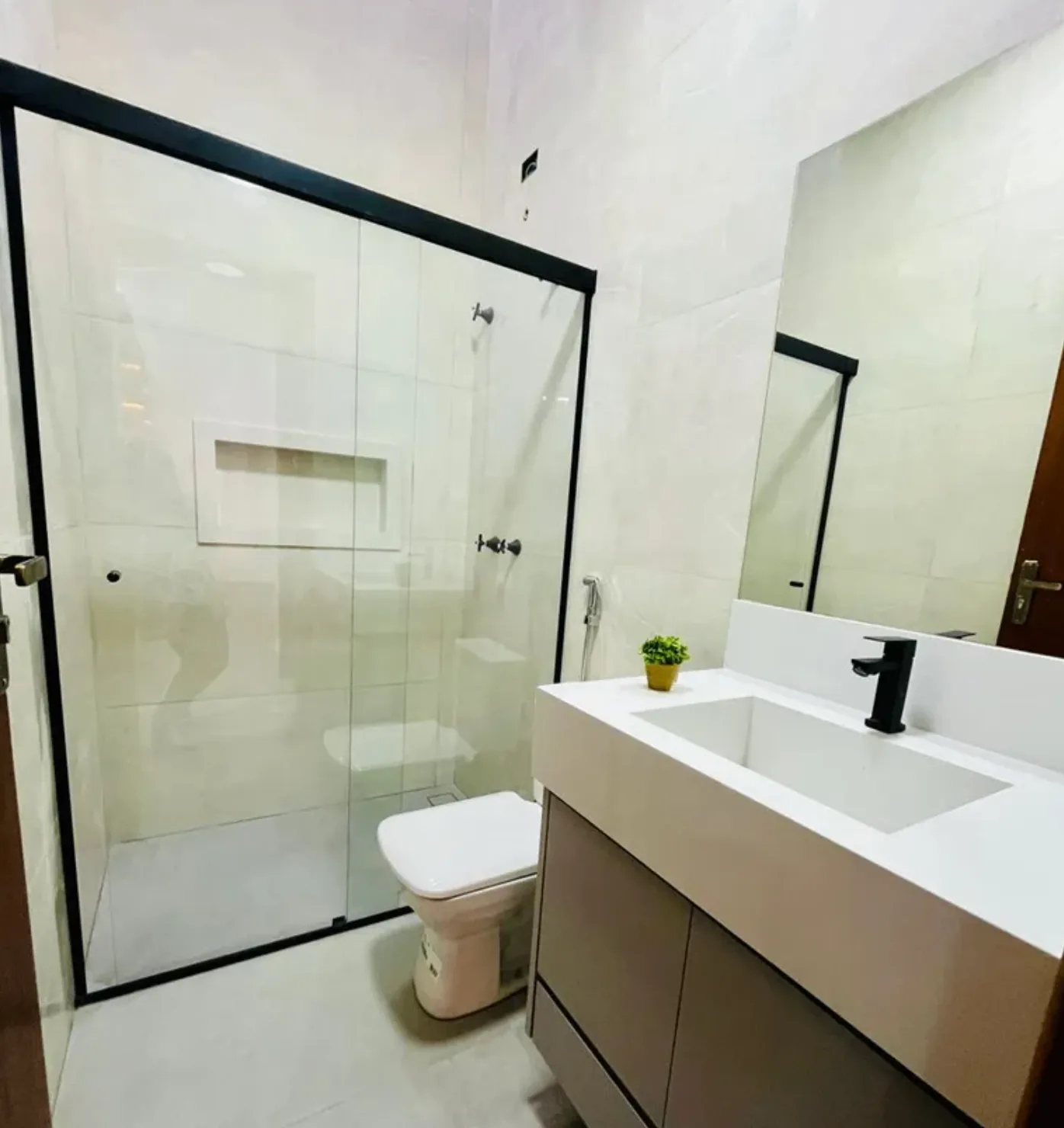 Banheiro com box de vidro e bancada de mármore
