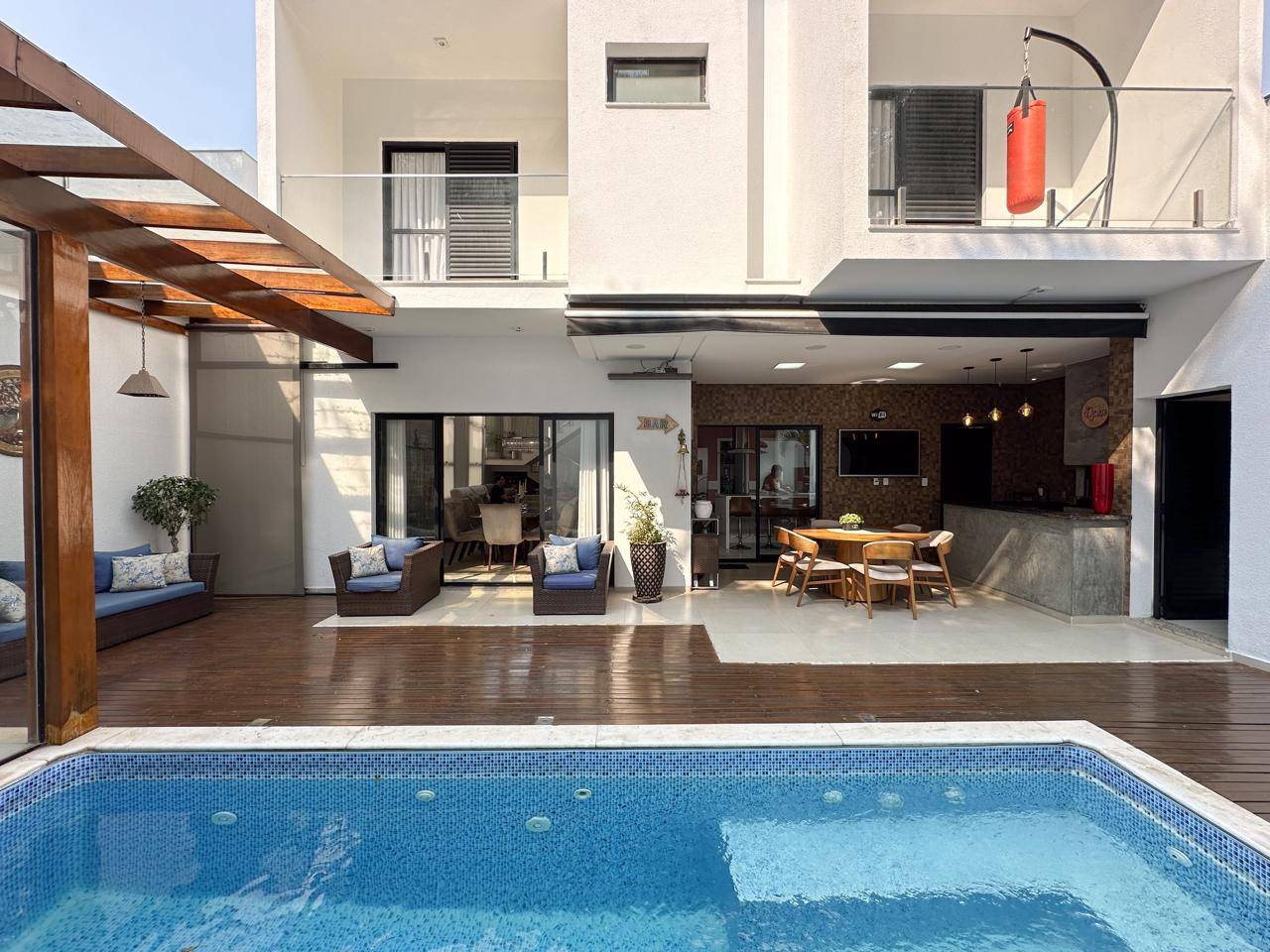 Área externa com piscina, deck em madeira e espaço gourmet da casa no Condomínio Villa dos Inglezes, Sorocaba