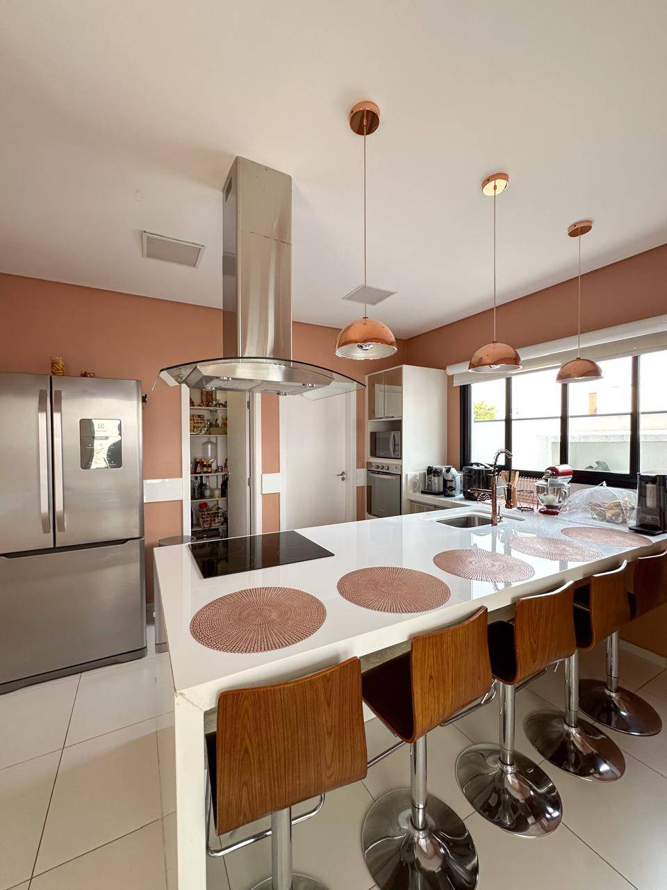 Vista ampla da cozinha integrada com vista para a área externa e piscina
