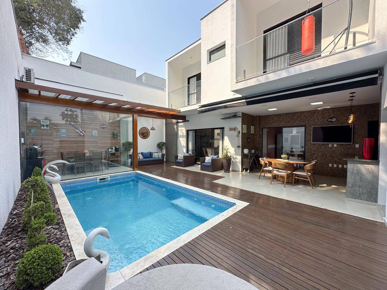 Piscina revestida com pastilhas, deck em madeira e pergolado no Condomínio Villa dos Inglezes