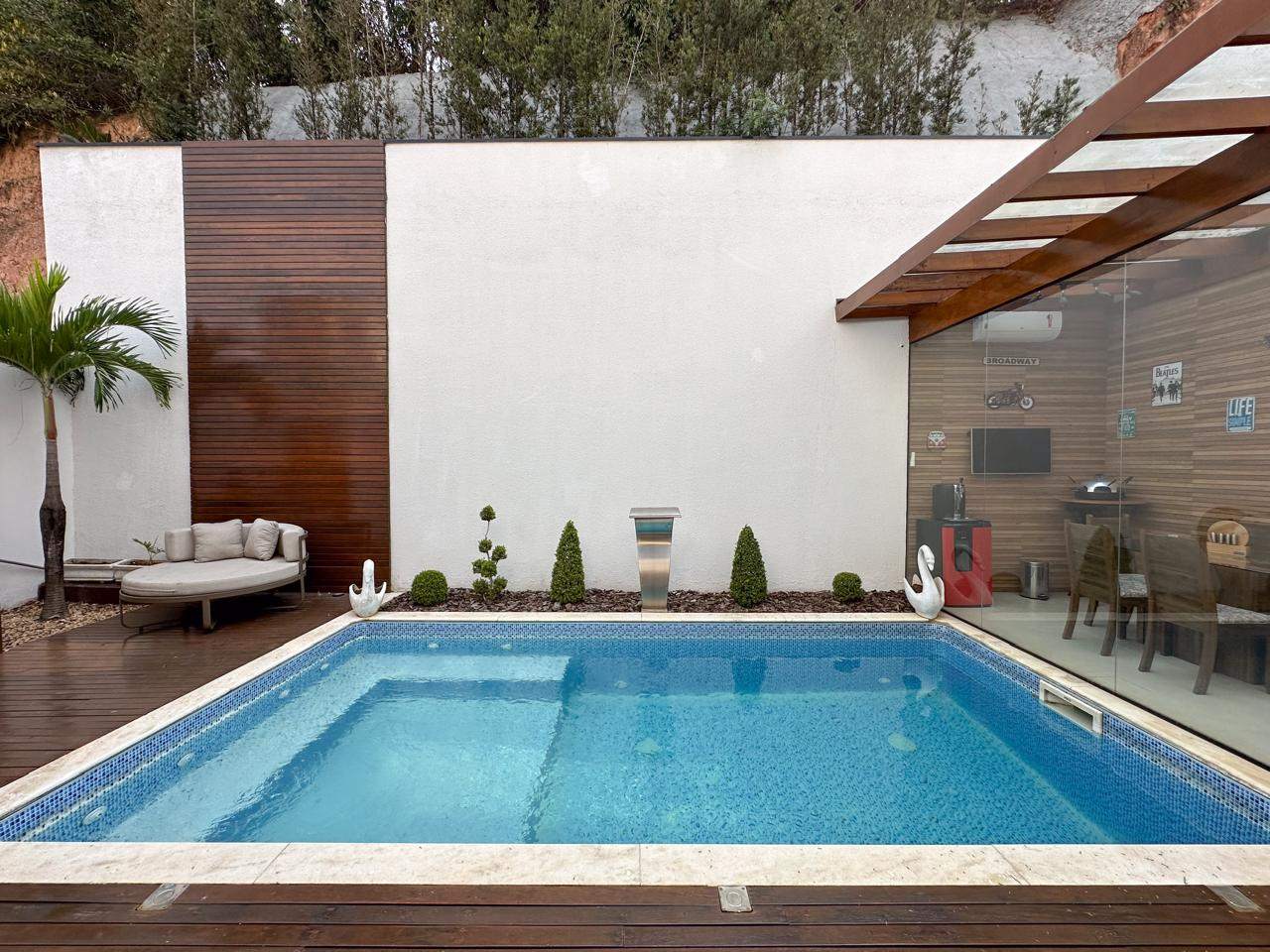 Detalhe da piscina com cascata em inox e paisagismo impecável