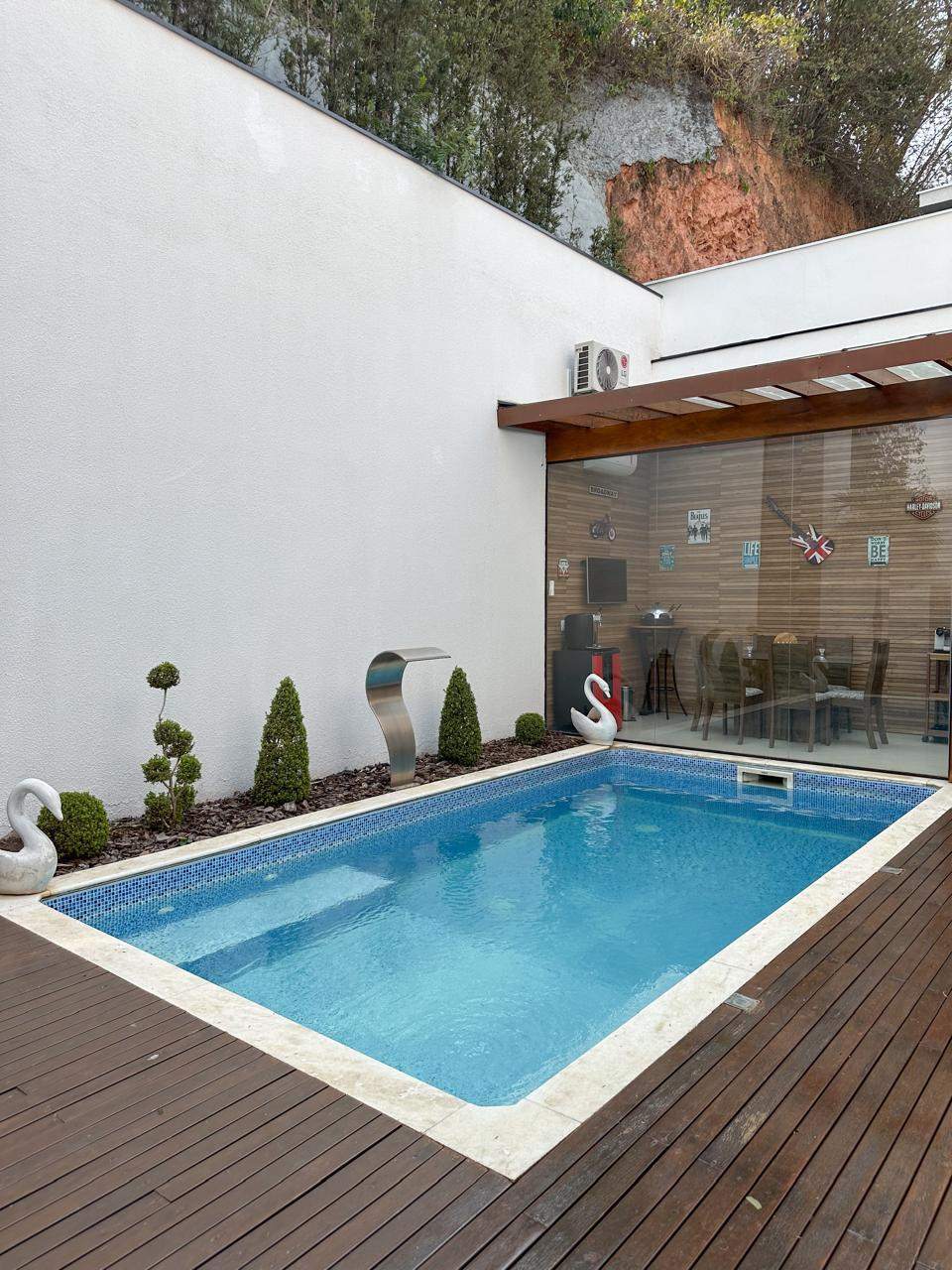 Vista lateral da área de lazer externa com piscina e espaço gourmet